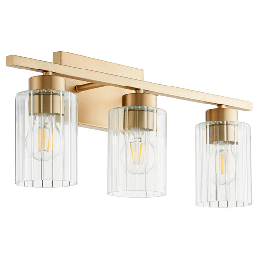  Ladin Three Light Vanity by Quorum in Aged Brass w/ Clear Fluted Glass Finish (501-3-280)